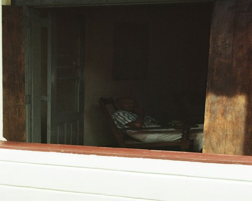 Person relaxing and drinking tea looking through a bright window